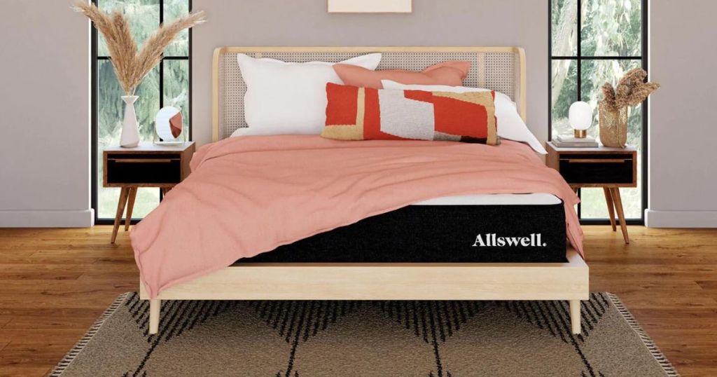 Allswell mattress with pink comforter and pillows on bed in bedroom