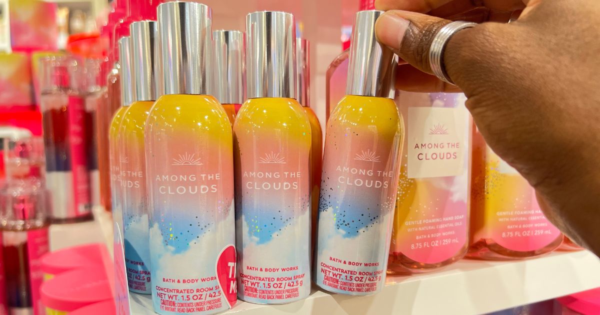 hand grabbing Among The Clouds room spray from store display