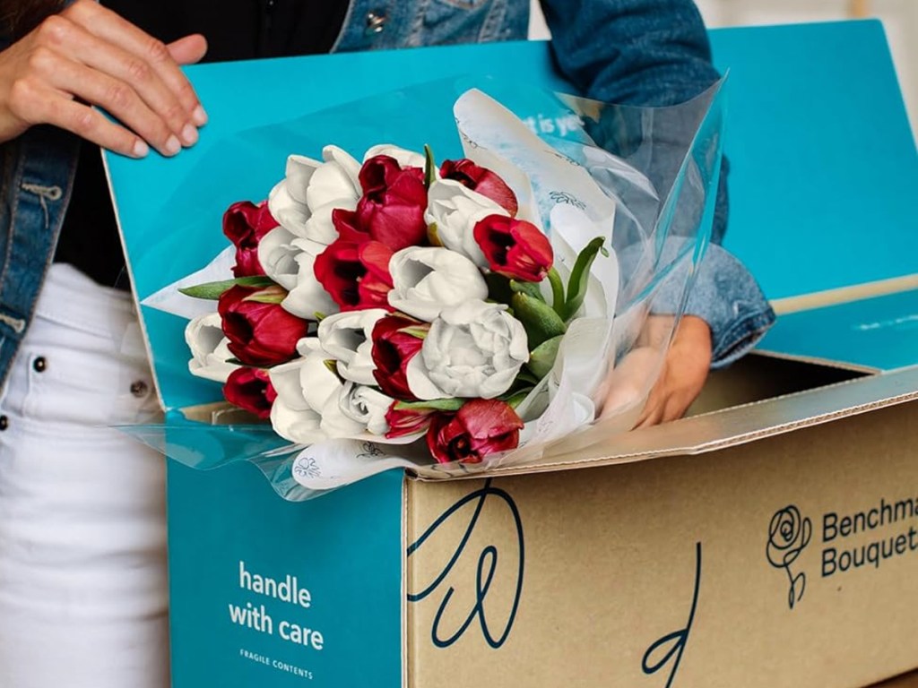 taking bouquet of red and white tulips out of shipping box