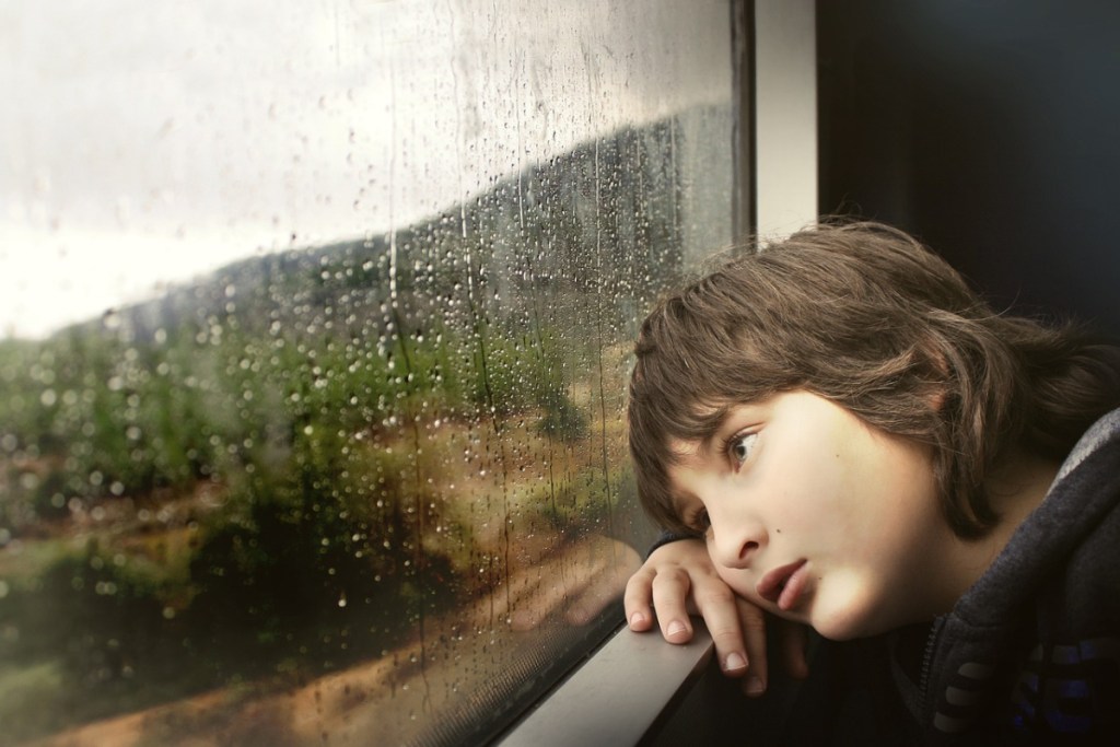 child looking out window of train or bus - free Greyhound bus tickets