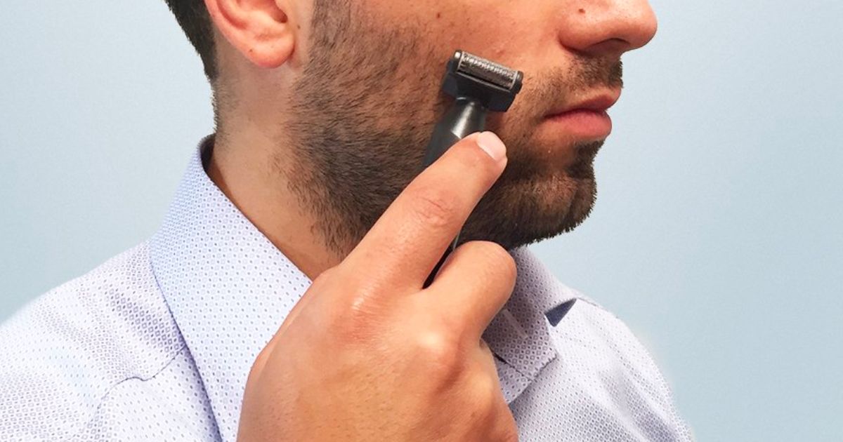 a man using a Conair men's trimmer to edge his beard with an attachment