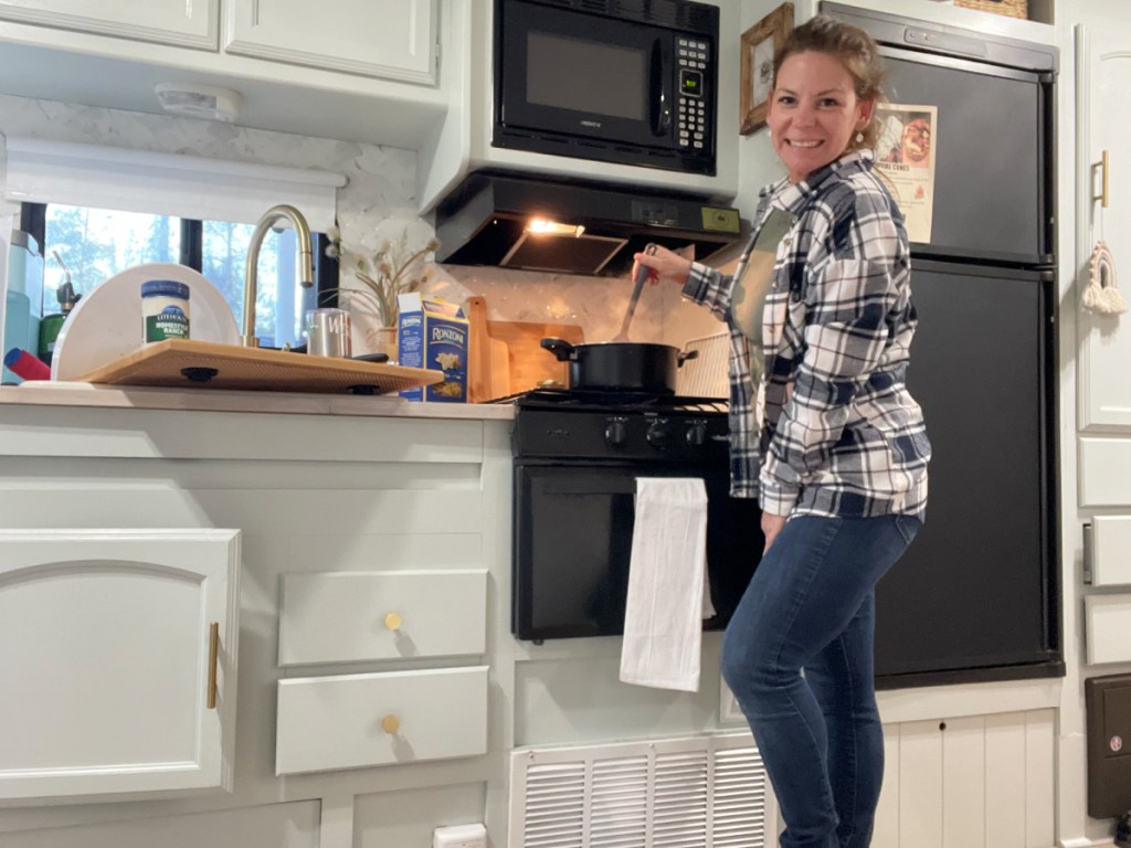 Woman cooking in an RV kitchen from RVshare