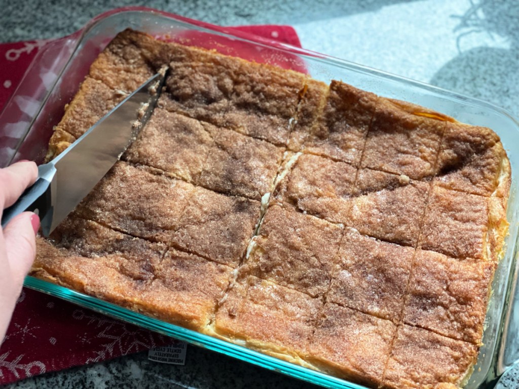 Using a knife to cut into a homemade dessert in a baking pan