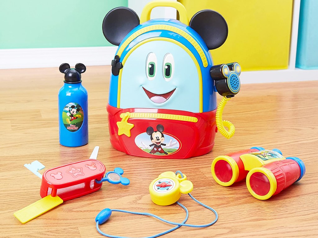 mickey mouse backpack and toys on wood floor
