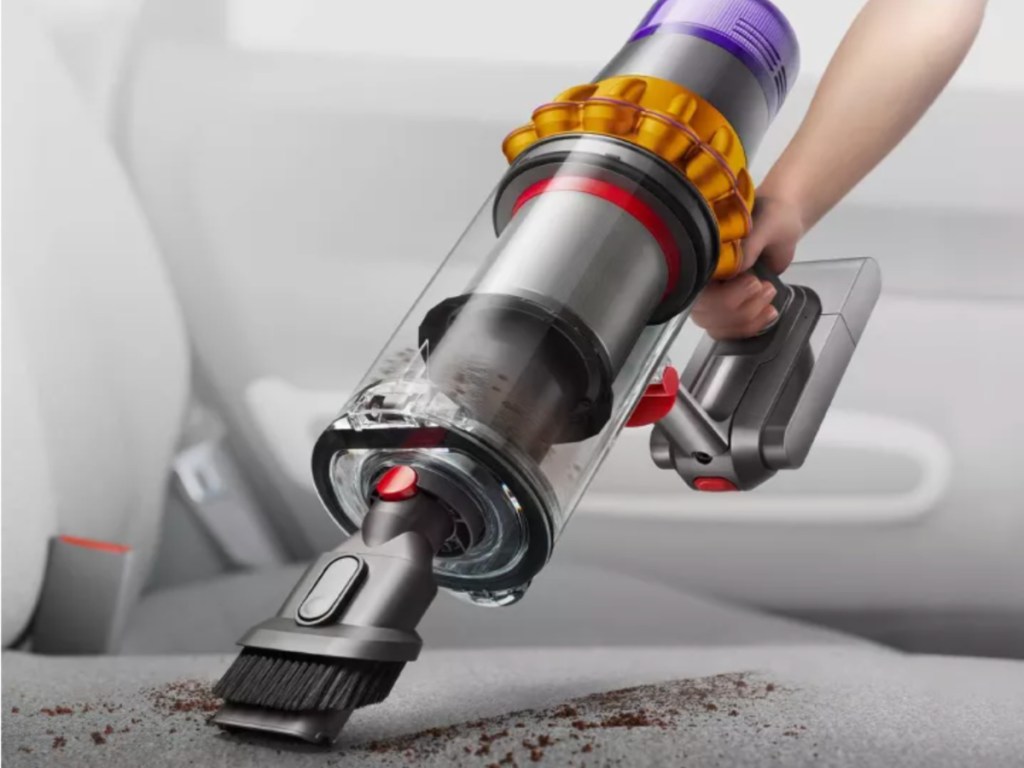 hand holding silver vacuum cleaner