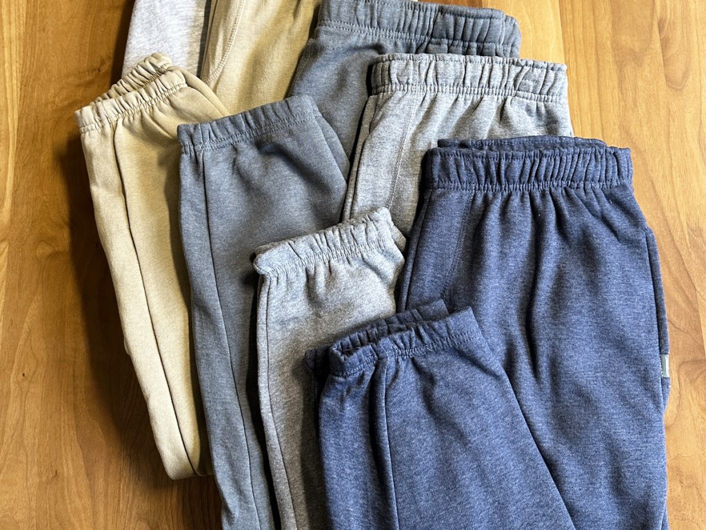 folded pairs of eddie bauer joggers on floor