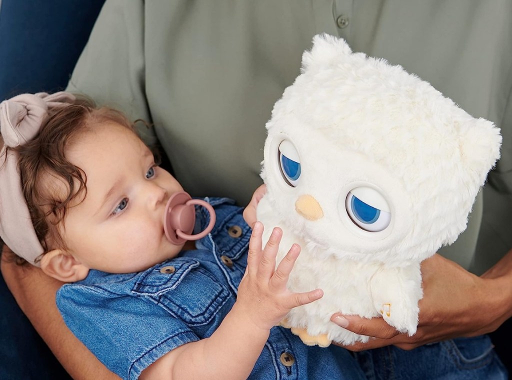 Baby girl holding a stuffed animal owl