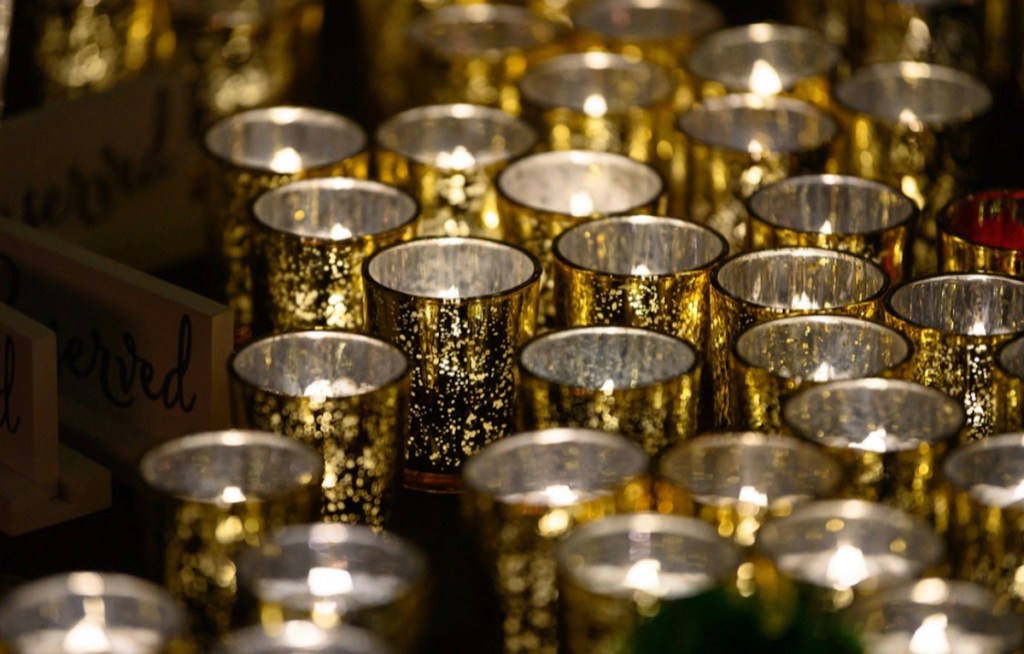 Tons of gold mercury votive candle holders with lit tea lights inside
