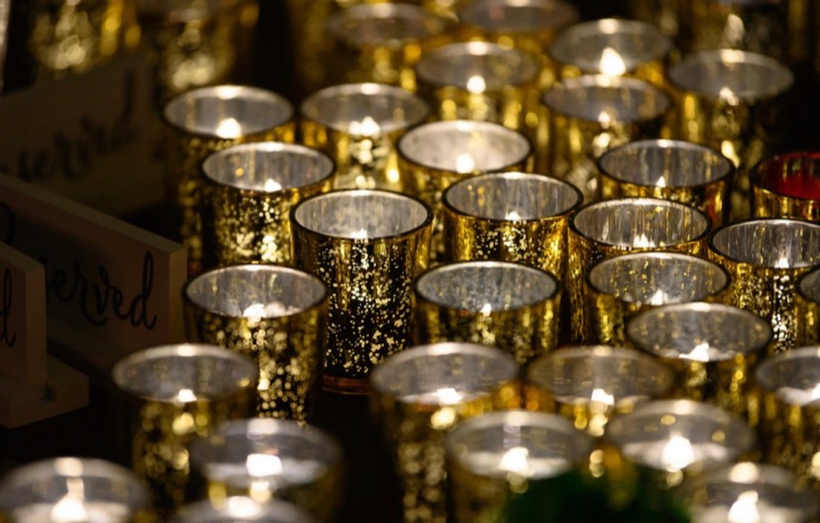 Tons of gold mercury votive candle holders with lit tea lights inside