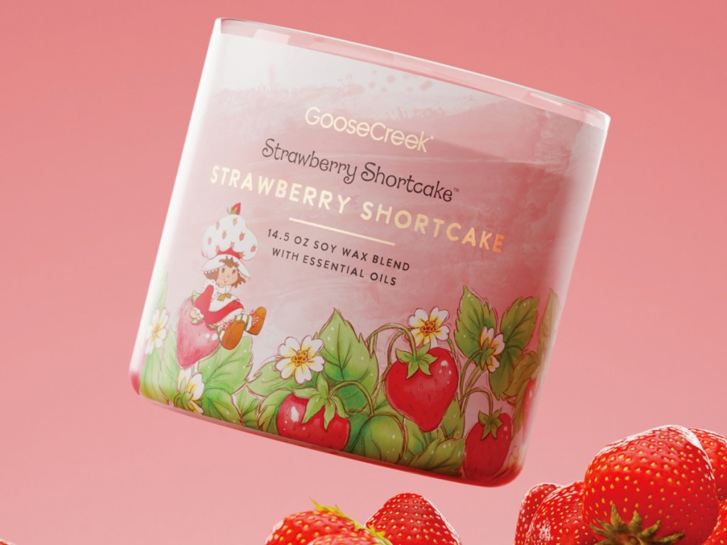 strawberry shortcake 3 wick candle with strawberries below it