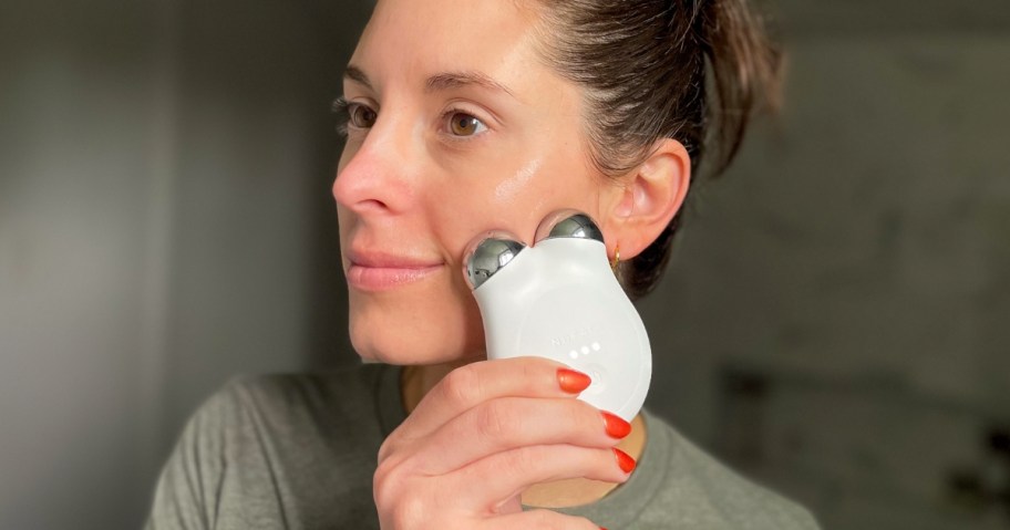 woman using a white NuFace mini tool on her face