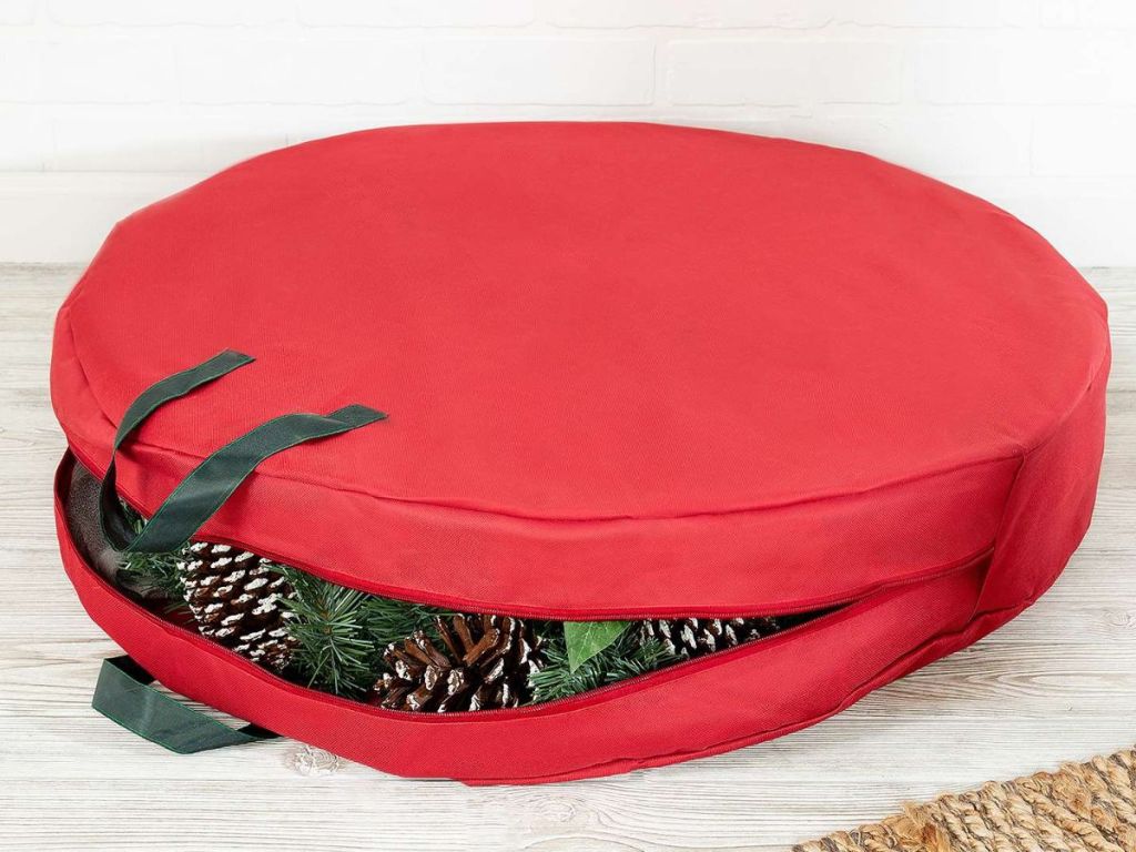 Honey-Can-Do red Canvas Wreath Storage Bag with wreath inside sitting on floor