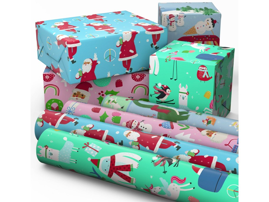 4 rolls of christmas wrapping paper in front of wrapped boxes