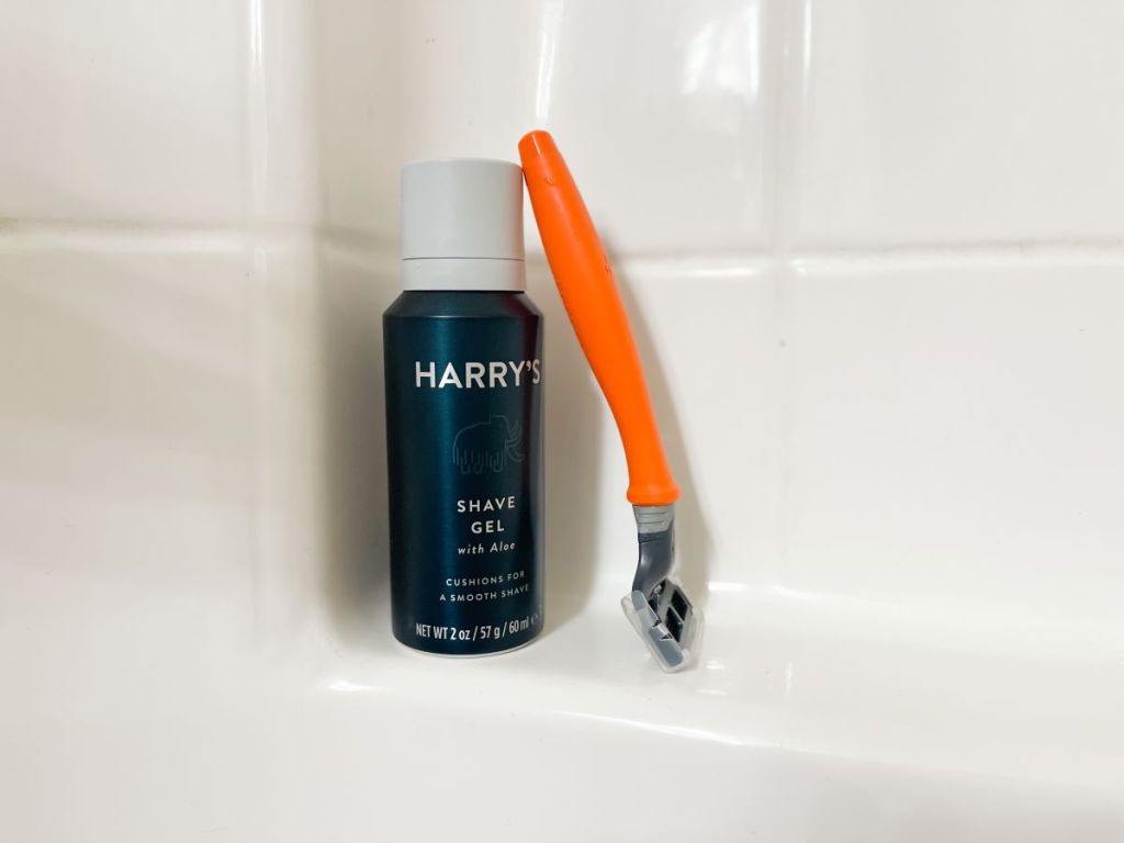 Harry's shave gel and razor in a bathtub.