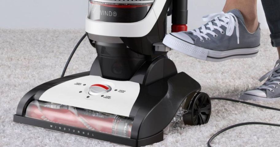 woman's foot stepping on the cord rewind feature on a Hoover Vacuum