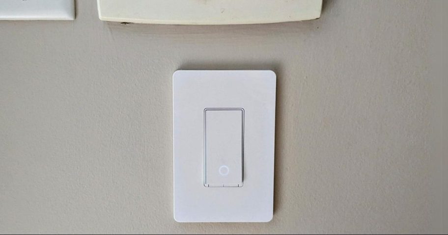 a kasa smart switch installed under a home security panel