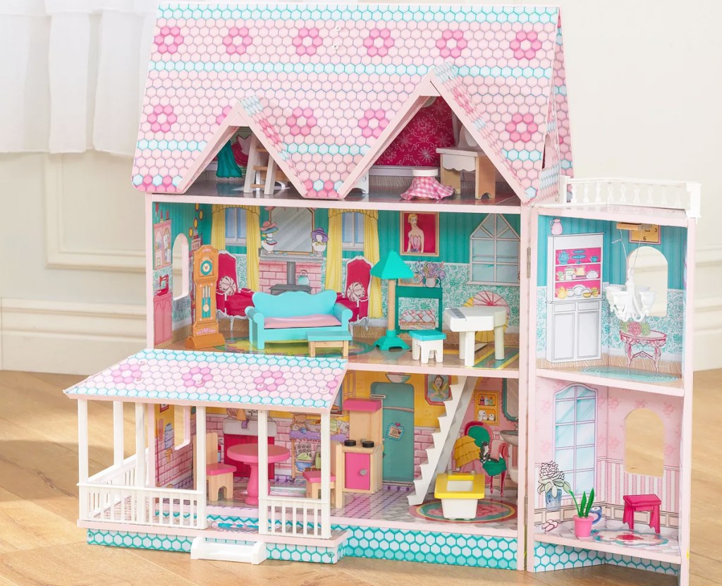 pink and blue kidkraft dollhouse on wood floor
