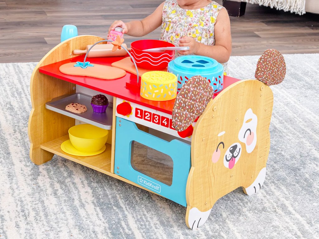 little girl playing with dog shaped kitchen playset