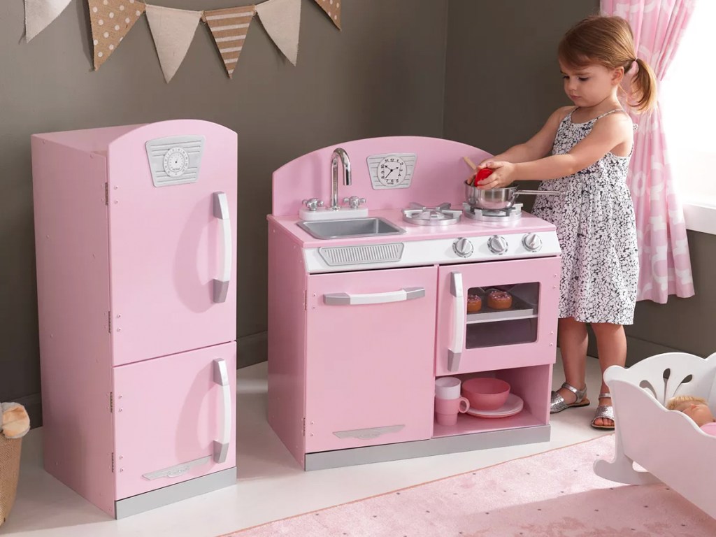 girl playing with pink retro kitchen playset
