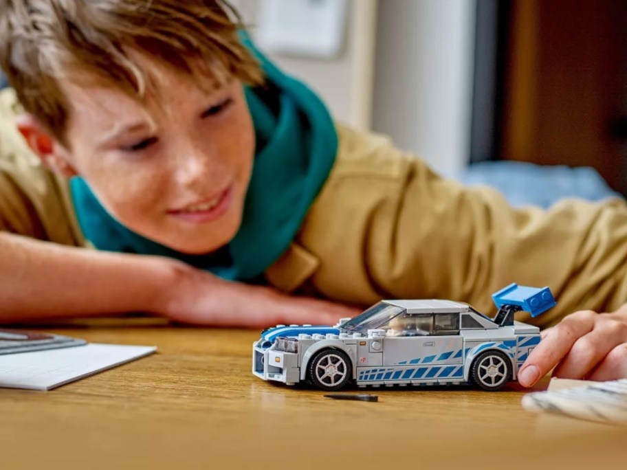 boy playing with LEGO car