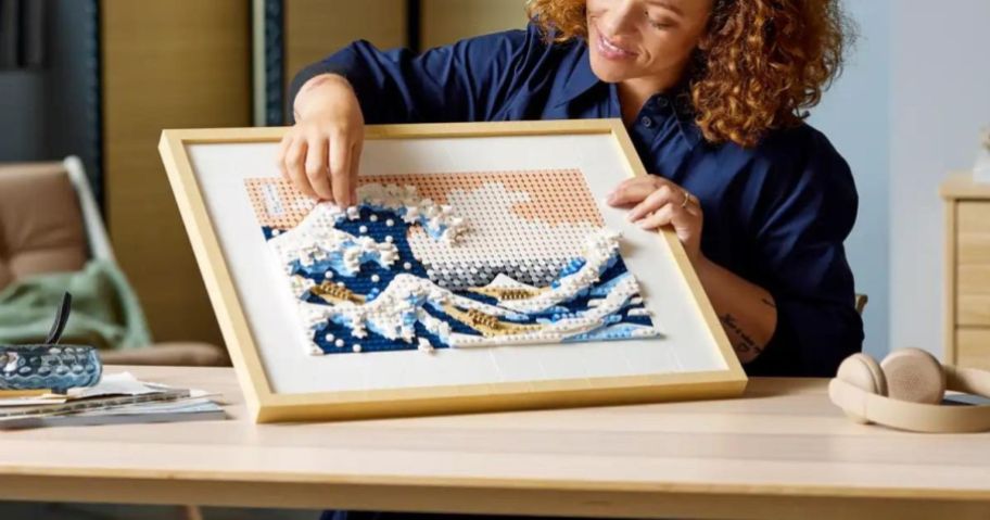 A person constructing a Lego ART Hokusai The Great Wave