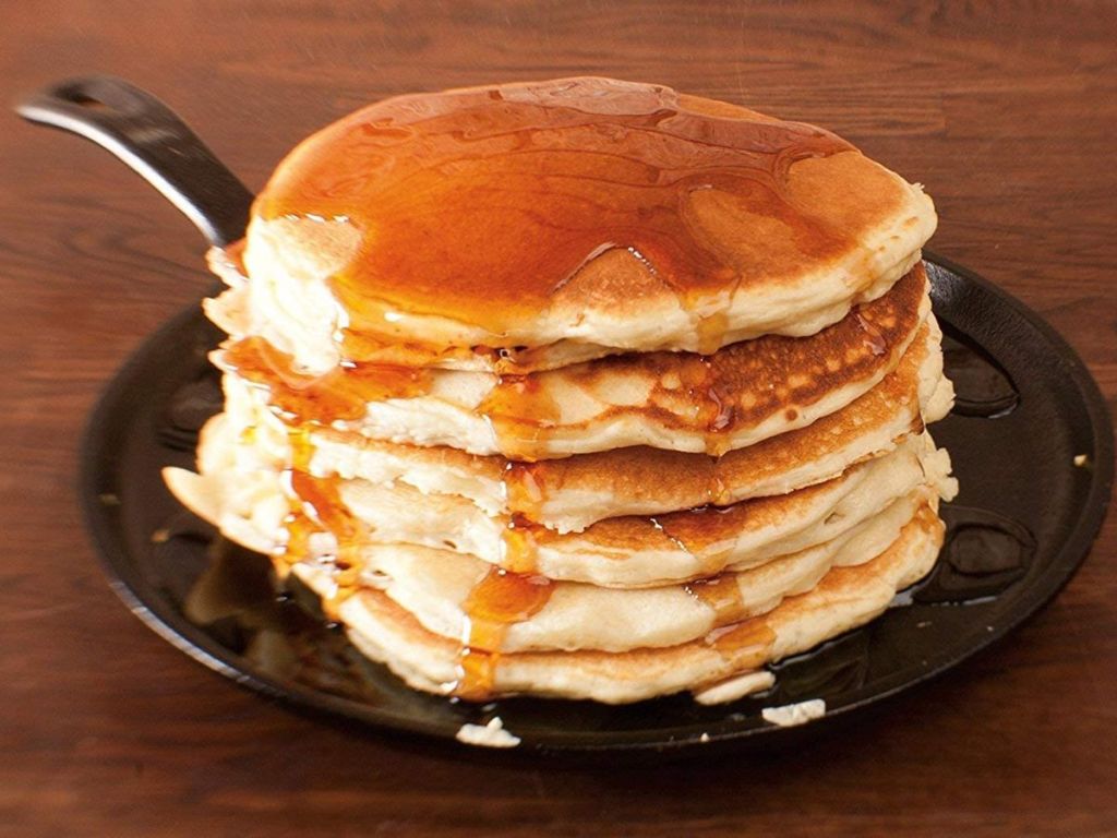 cast iron griddle with stack of pancakes on it