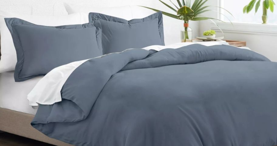 A bed with a blue duvet cover on it