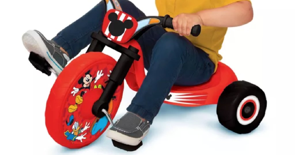 child on red toy bike