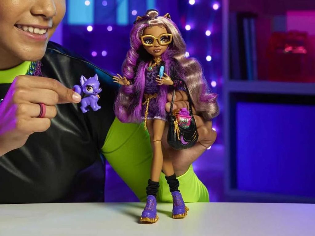 Little girl playing with a Monster High Clawdeen Wolf doll
