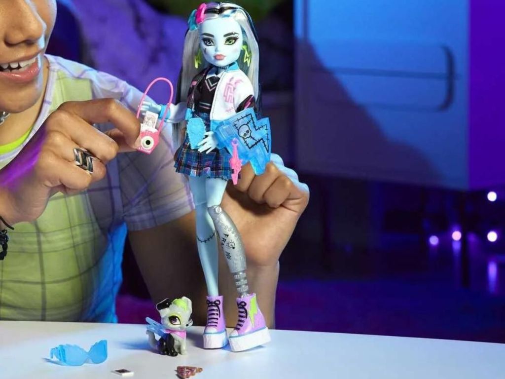 Little girl playing with a Monster High Frankie Stein doll