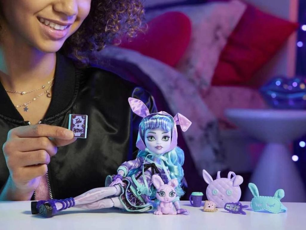 Little girl playing with a Monster High Twyla Doll