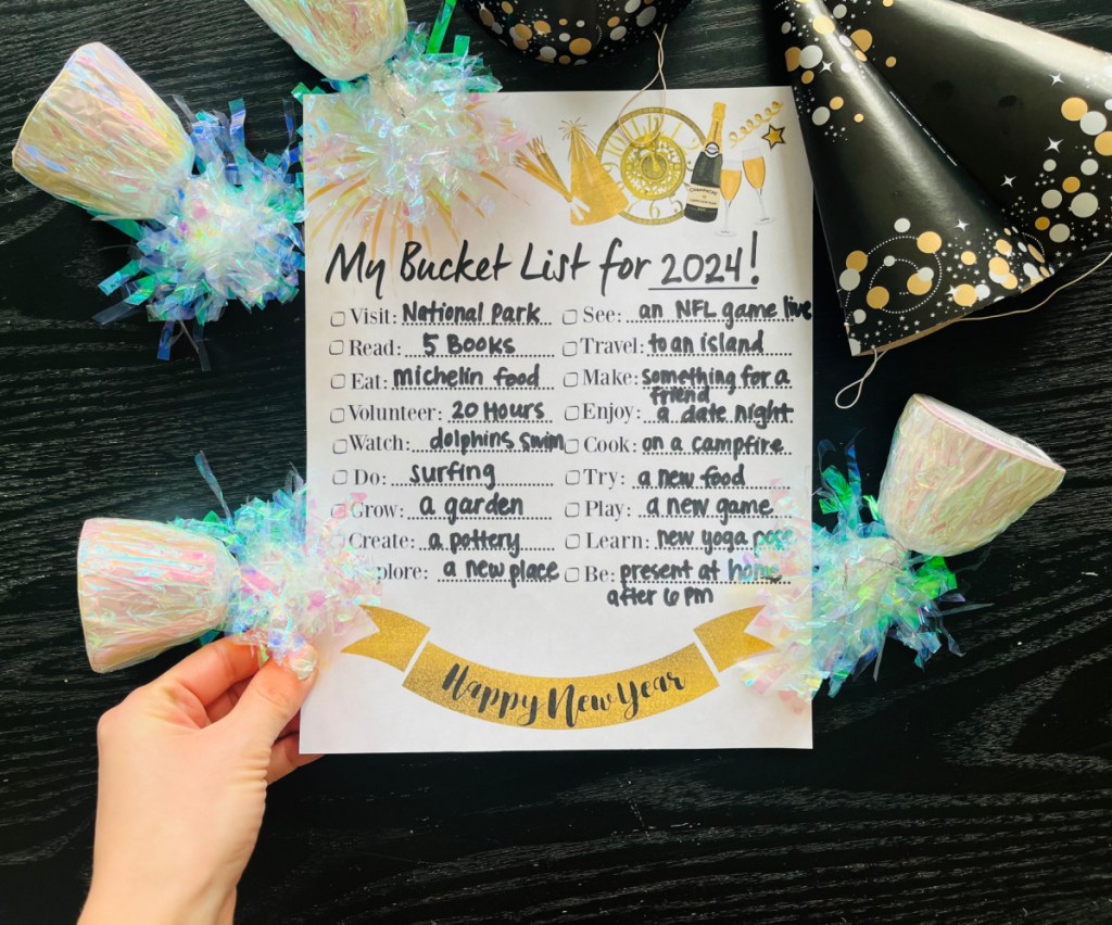 Hand holding their 2024 New Years Bucket List free printable