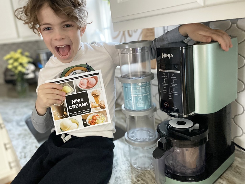 boy on kitchen counter next to ninja creami machine