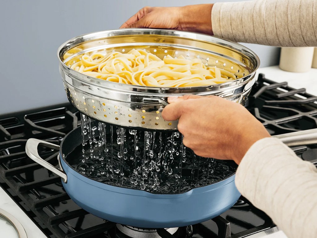 hands draining pasta from Ninja Foodi NeverStick PossiblePan