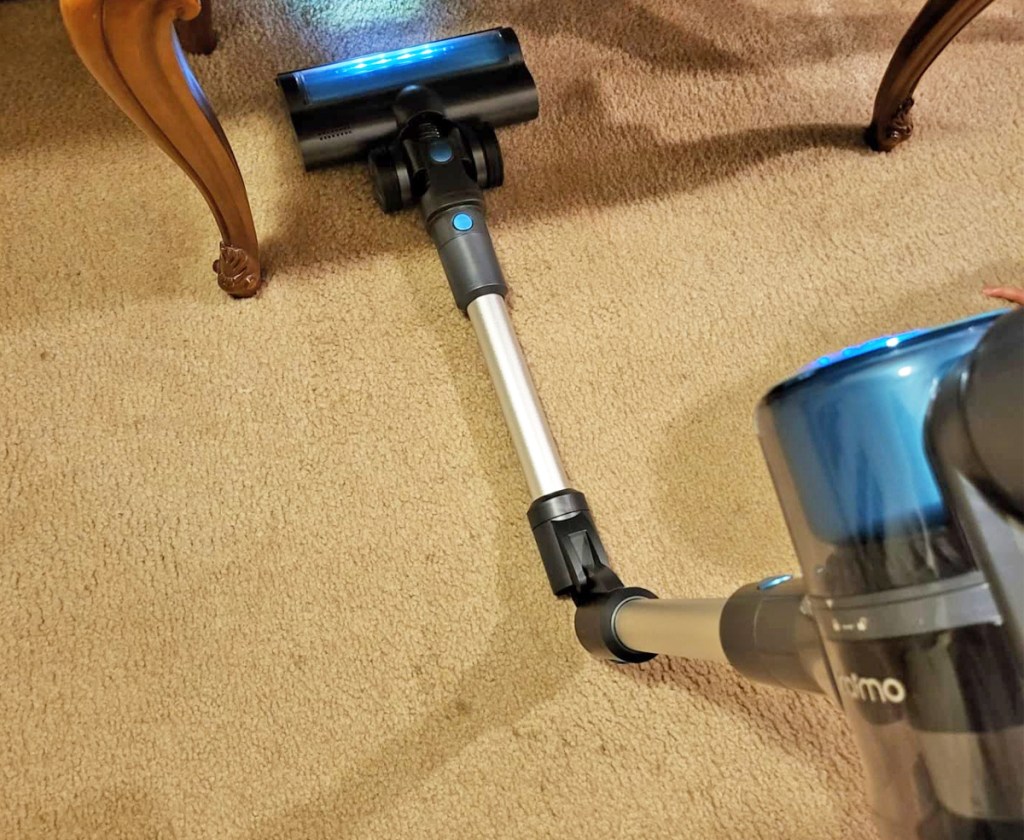 stick vacuum with a bendable tube cleaning under a table