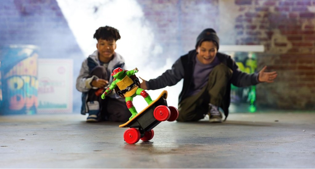 kids playing with a remote control ninja turtle on a skateboard