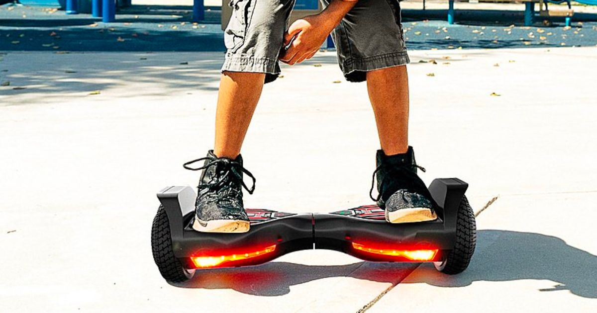 a little boys feet as hes standing on a SWAGTRON Swagboard Twist T580 Hoverboard w/LED Wheels in a park