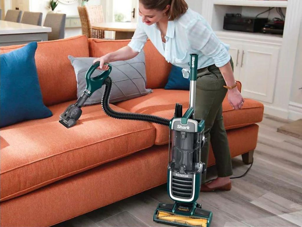 woman using attachment tool to vacuum couch