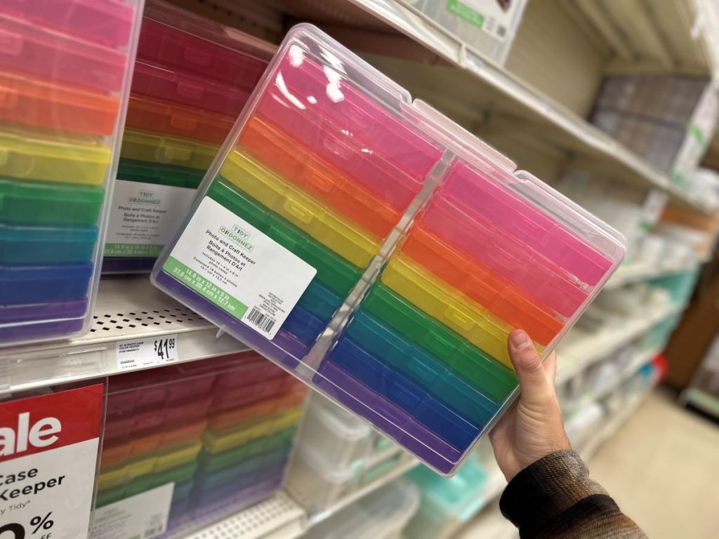 Hand holding a photo keeper storage system at Michaels