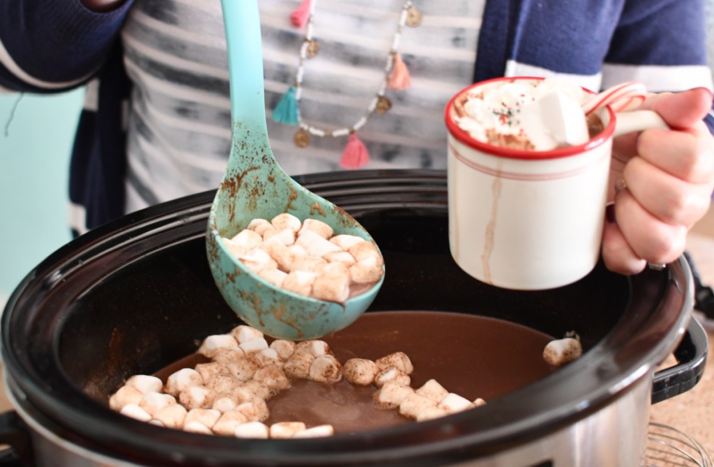 Using a ladle to fill a mug full of Crockpot hot chocolate