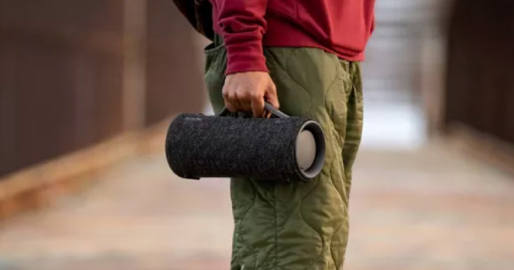 man holding black portable speaker