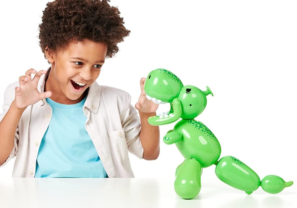 boy playing with Squeakee The Dino