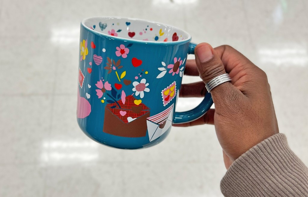 hand holding blue mug with love letters