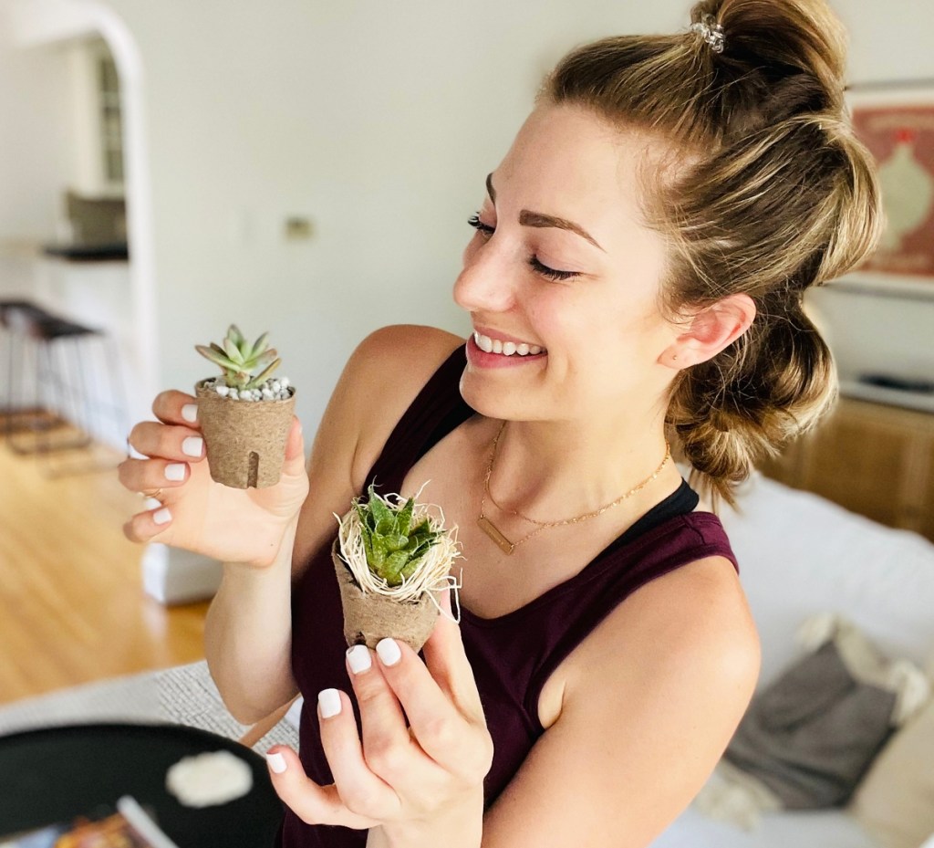 woman holding two baby succulents