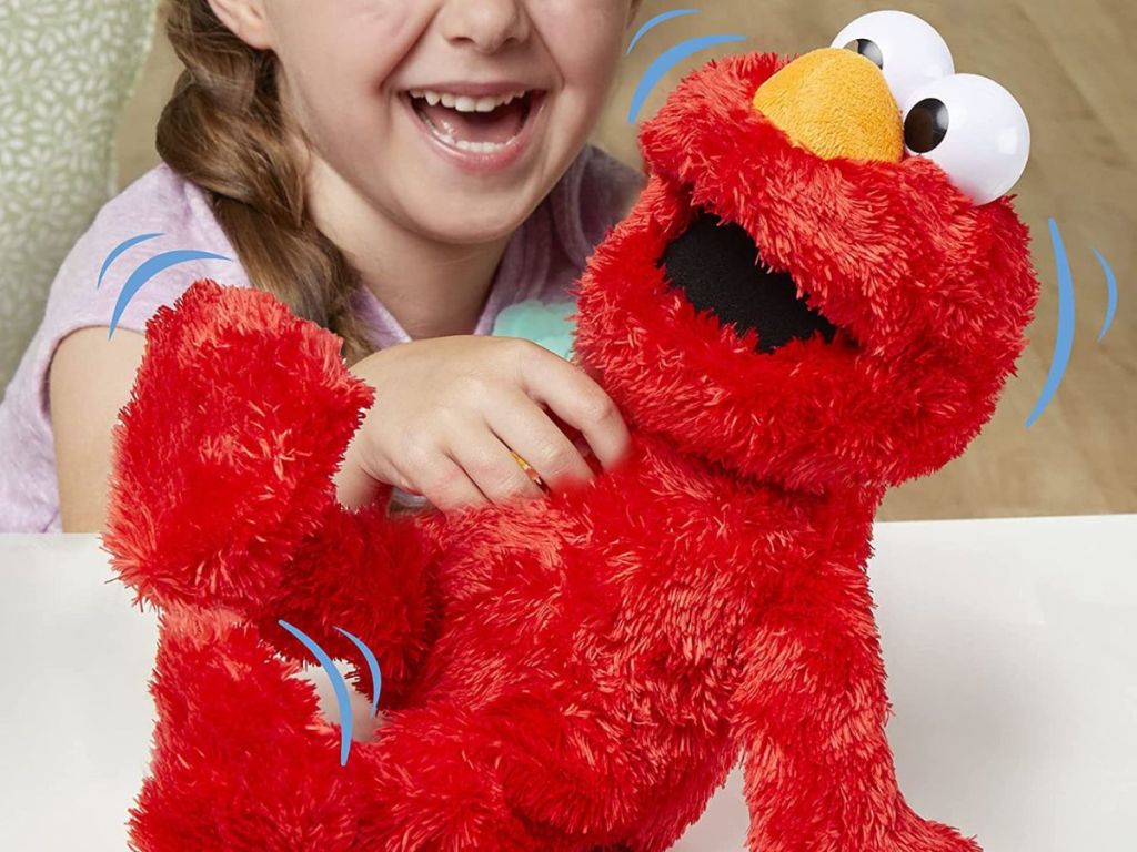 Girl tickling Elmo plush toy