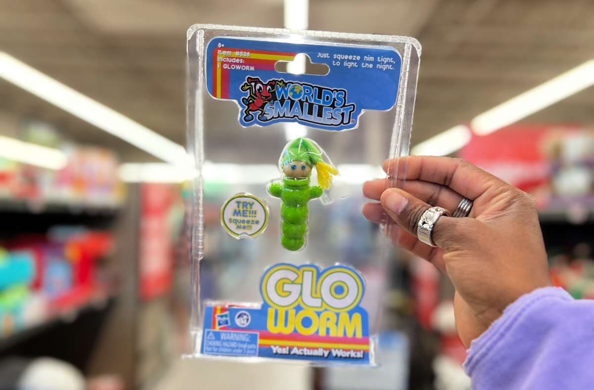 Hand holding up one of the world's smallest toys, the Glo Worm