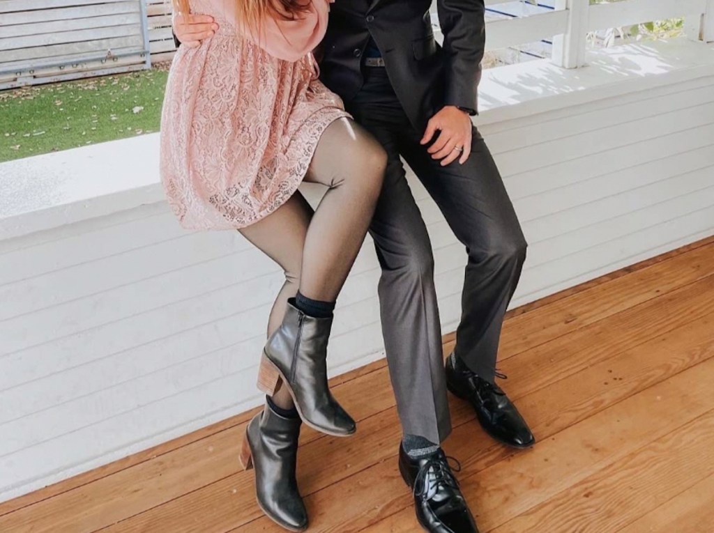 couple sitting on half wall wearing formal wear