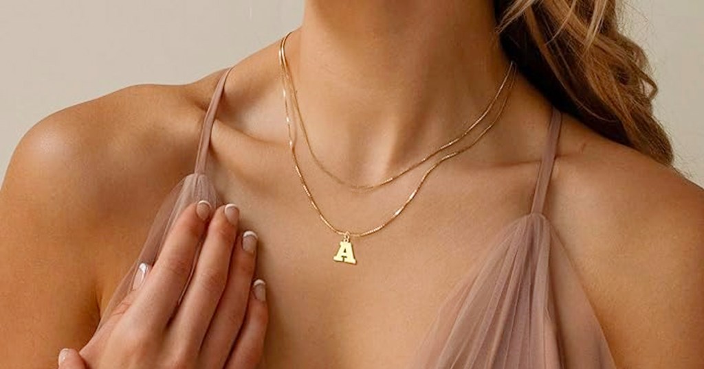 woman wearing gold initial necklace 