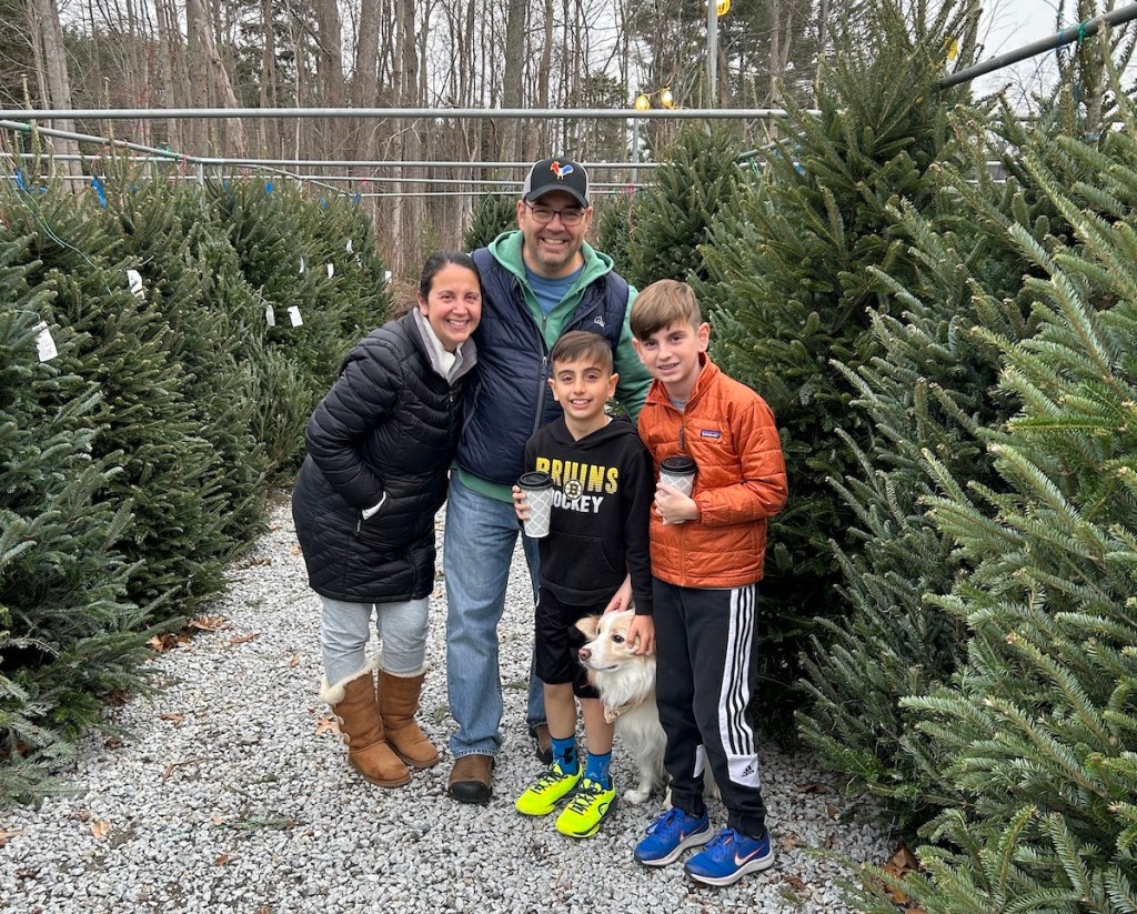 family standing in aisle at tree farm