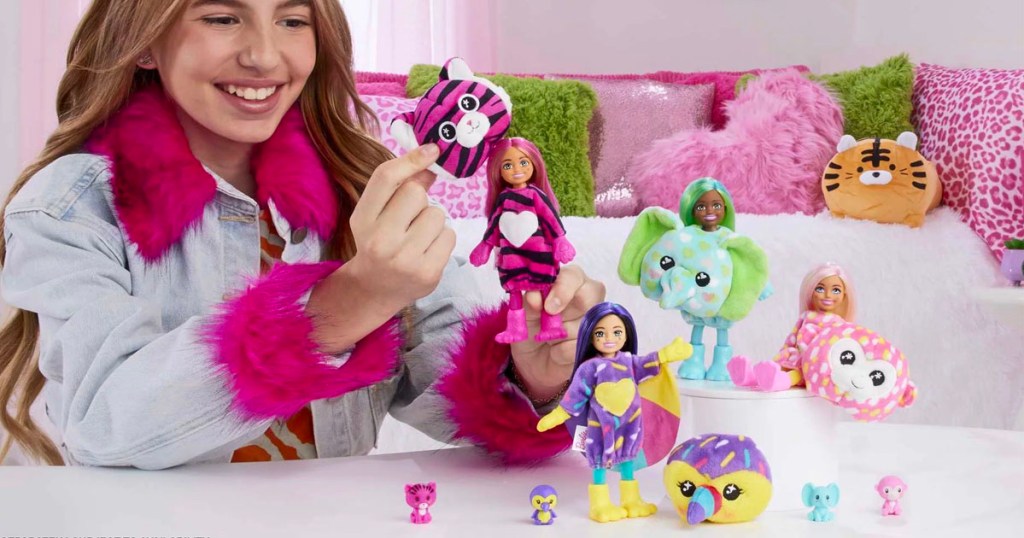 girl playing with two barbie cutie reveal dolls